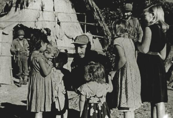 In a ceasefire, Commander Fidel Castro receives peasant girls who have come to greet him